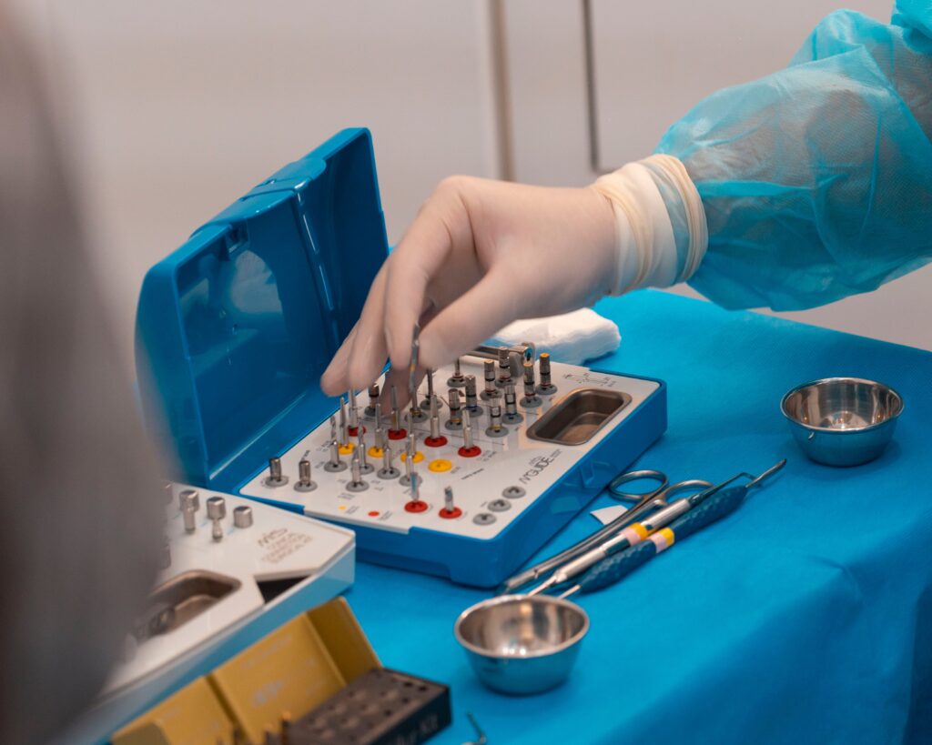 A surgeon's hand in gloves preparing instruments for surgery, emphasizing precision and cleanliness.
